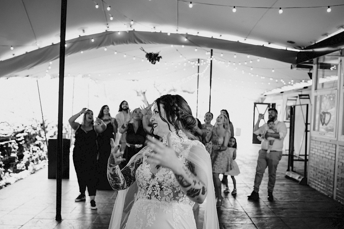 Novia lanzando el ramo hacia las invitadas de su boda en Astigarraga.