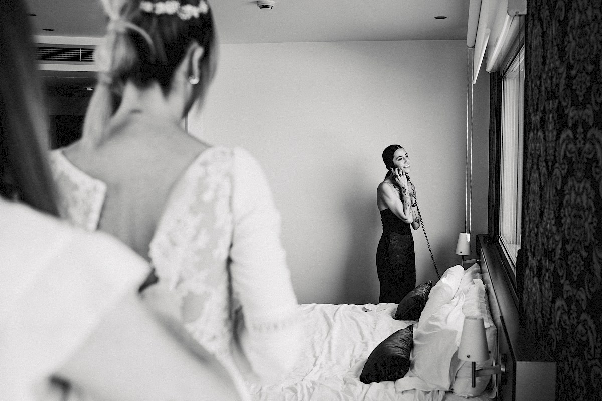 Una dama de honor llamando por telefono en los preparativos de Rebeca la novia.