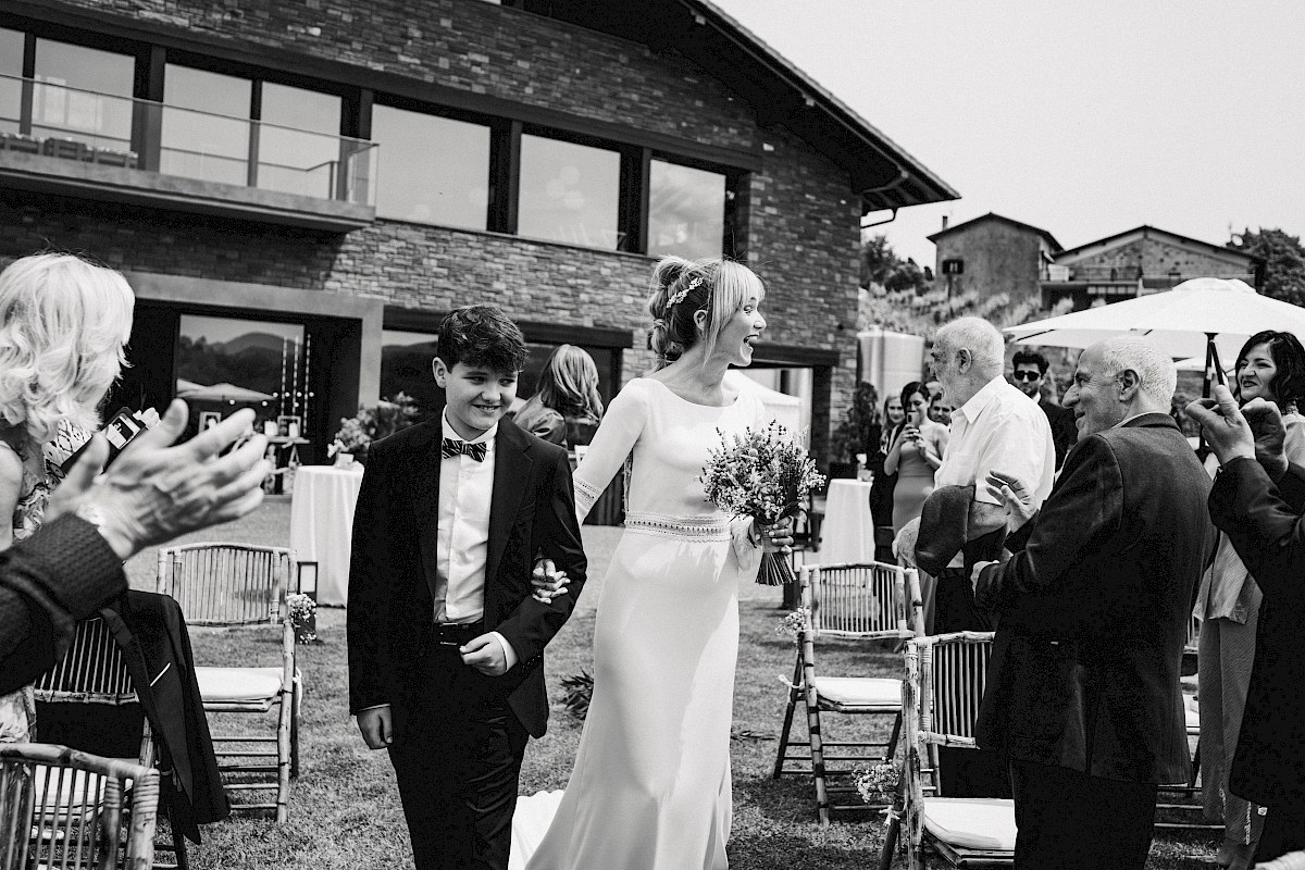 La novia llegando al altar de la mano de su hijo en la bodega katxiña en Orio