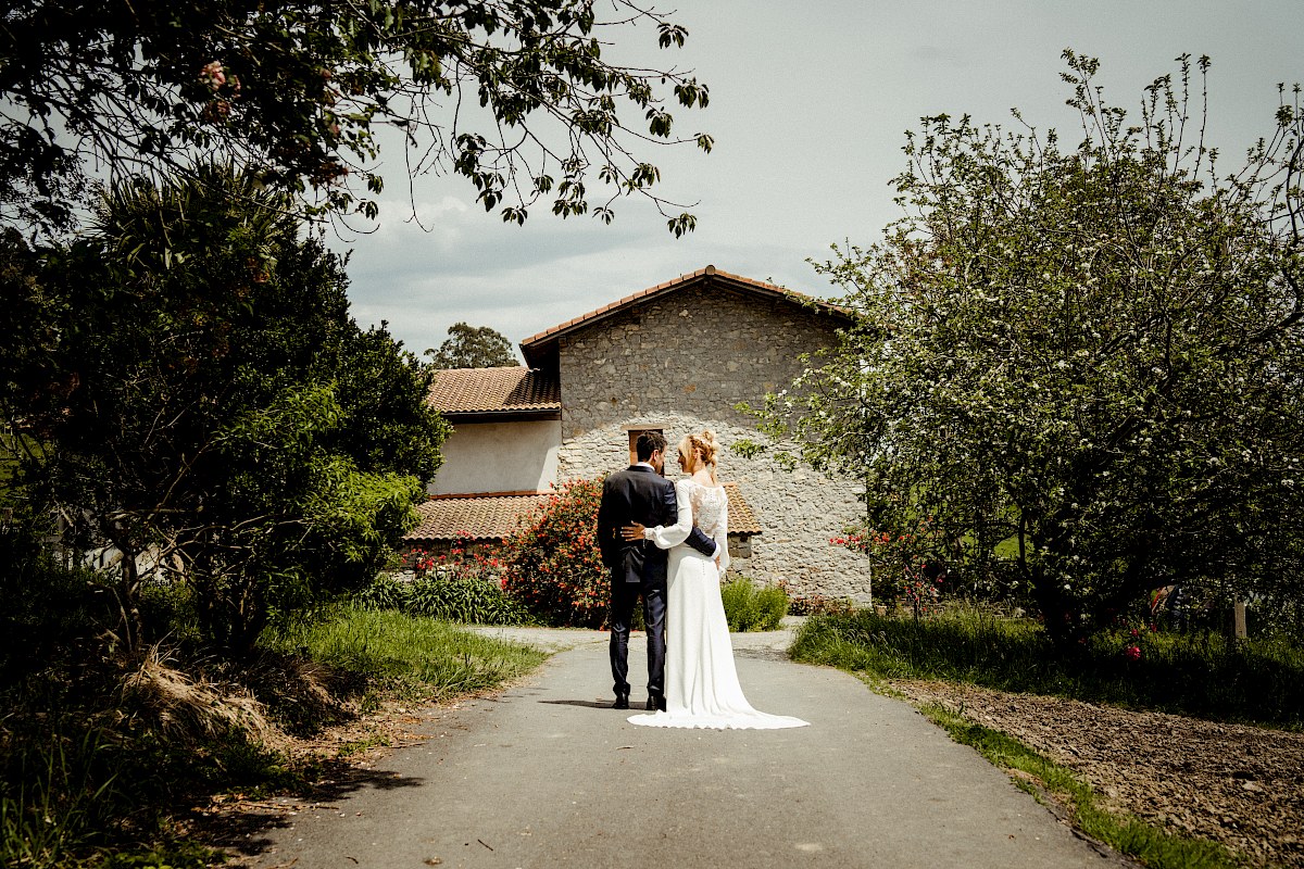 Los novios recien casados posan en un camino en el paseo fotografico de su boda en Orio